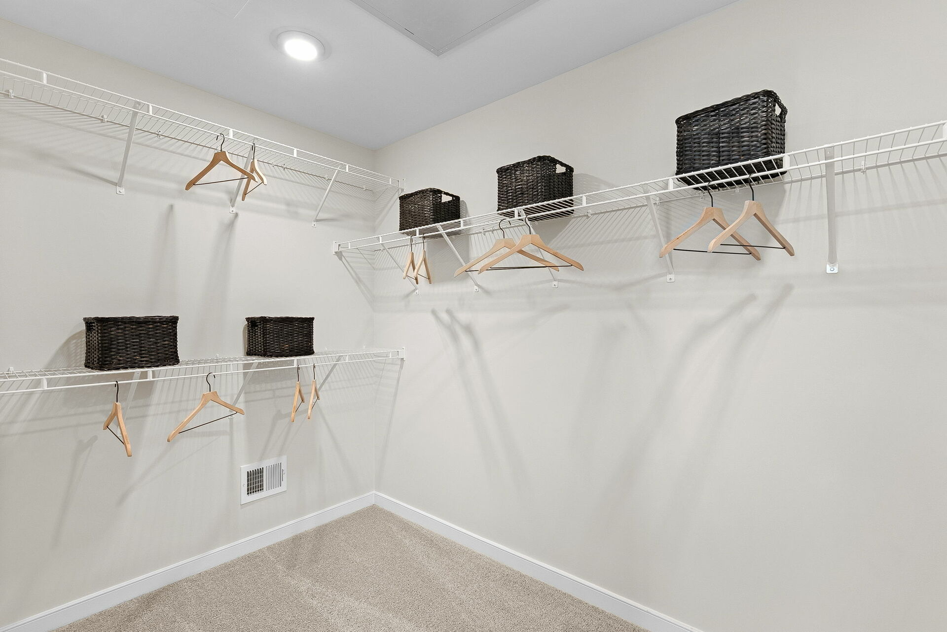 walk in closet with wired shelfing and coat racks