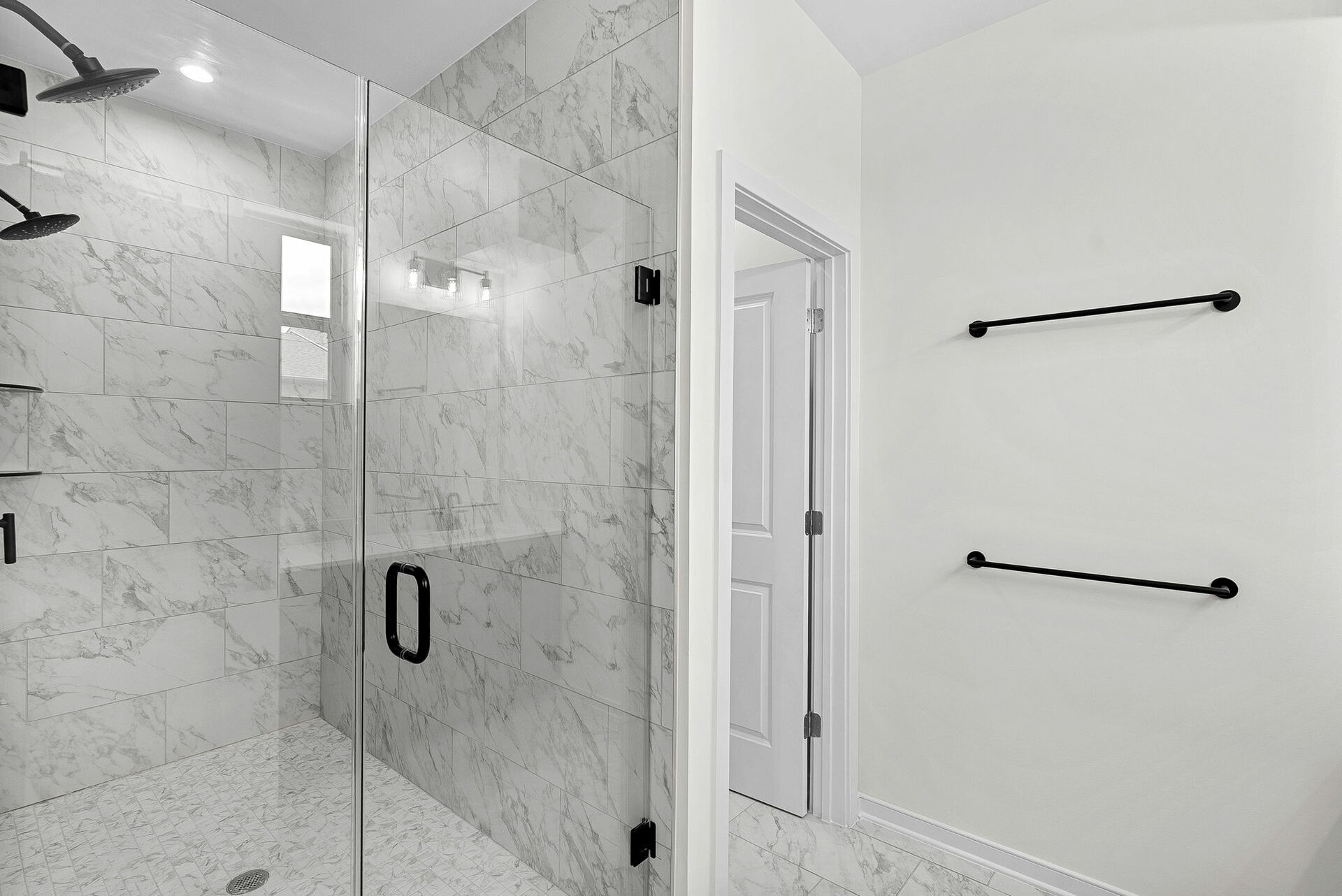 walk in shower with tile and black hardware
