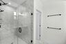 walk in shower with tile and black hardware