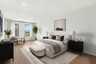 bedroom with hardwood floors windows and queen bed