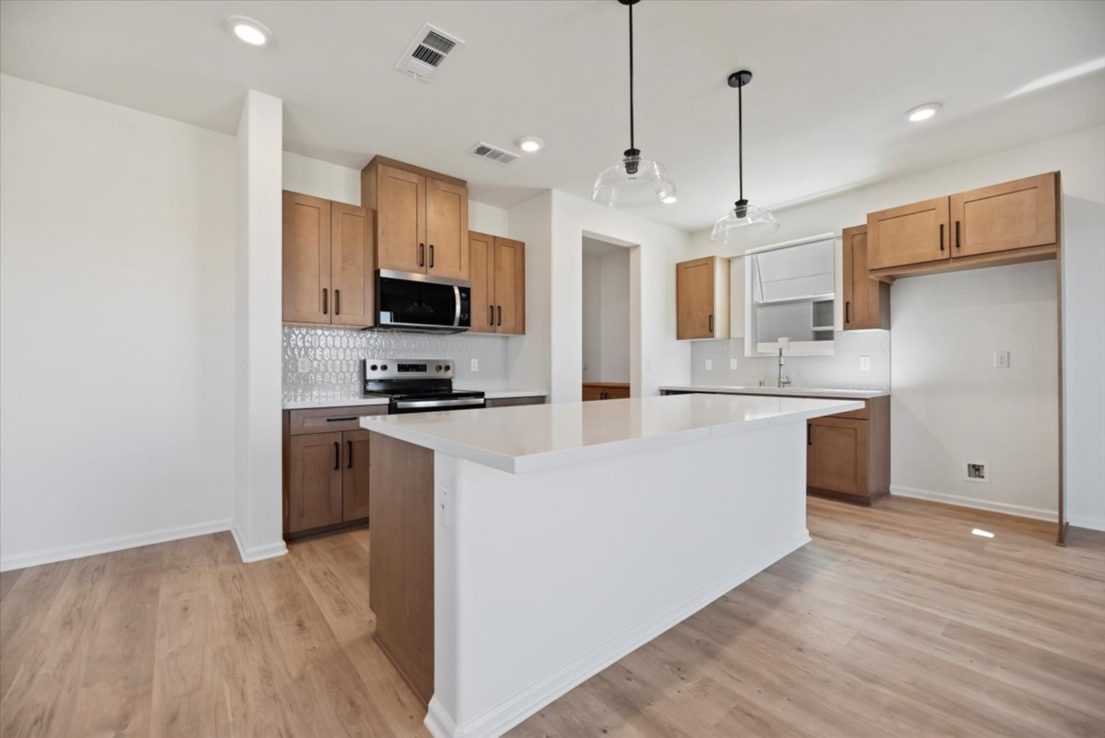 kitchen with a large white island and brown cabinets