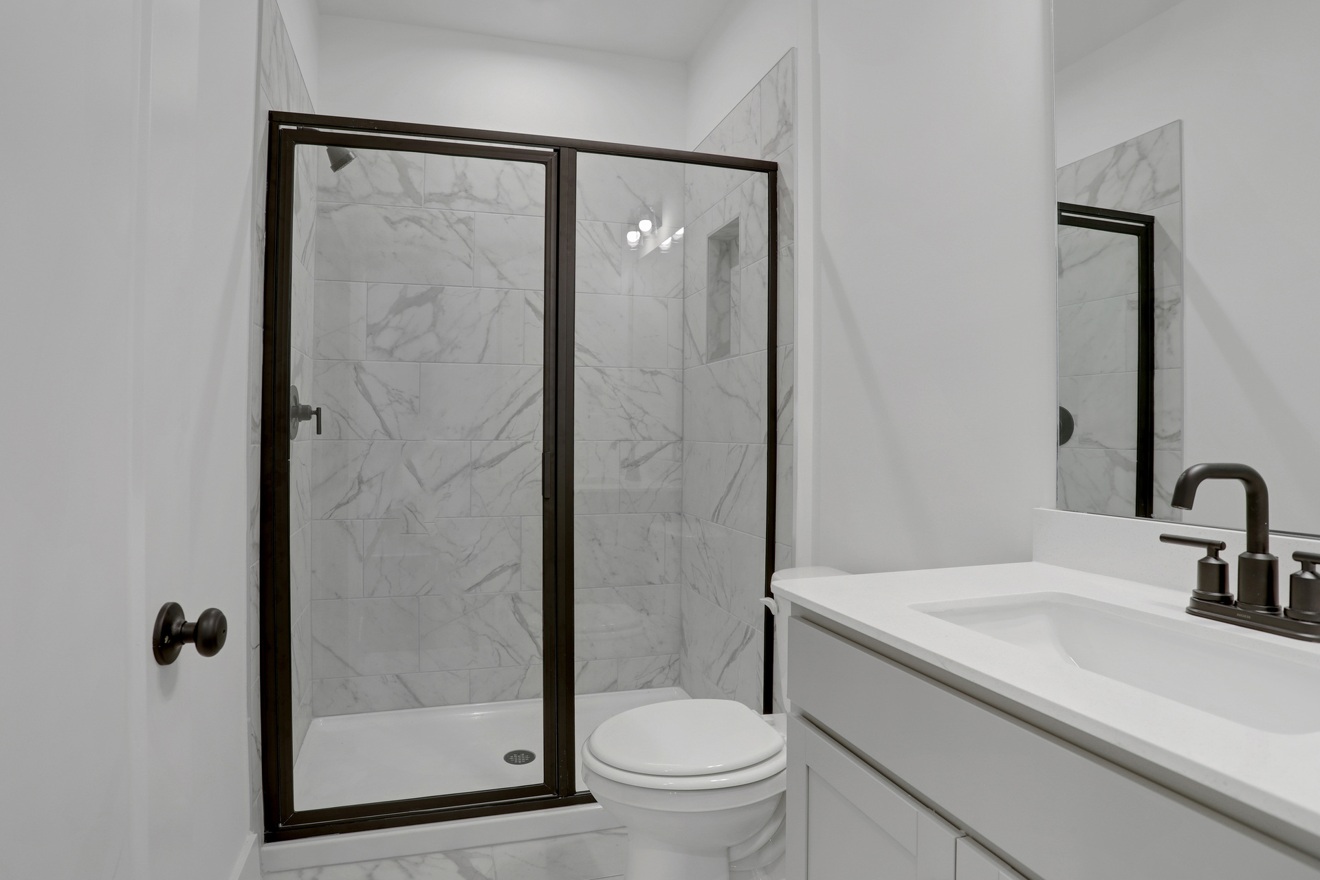 secondary bathroom with gray cabinets and tile flooring
