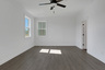 primary bedroom with windows and hard surface flooring