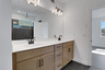 primary bathroom with wood-finish cabinets and tile flooring