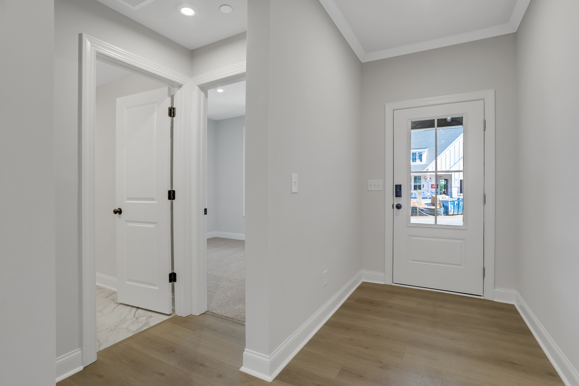 foyer with hard surface flooring and hallway for secondary bedrooms