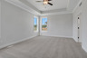 primary bedroom with windows and carpet