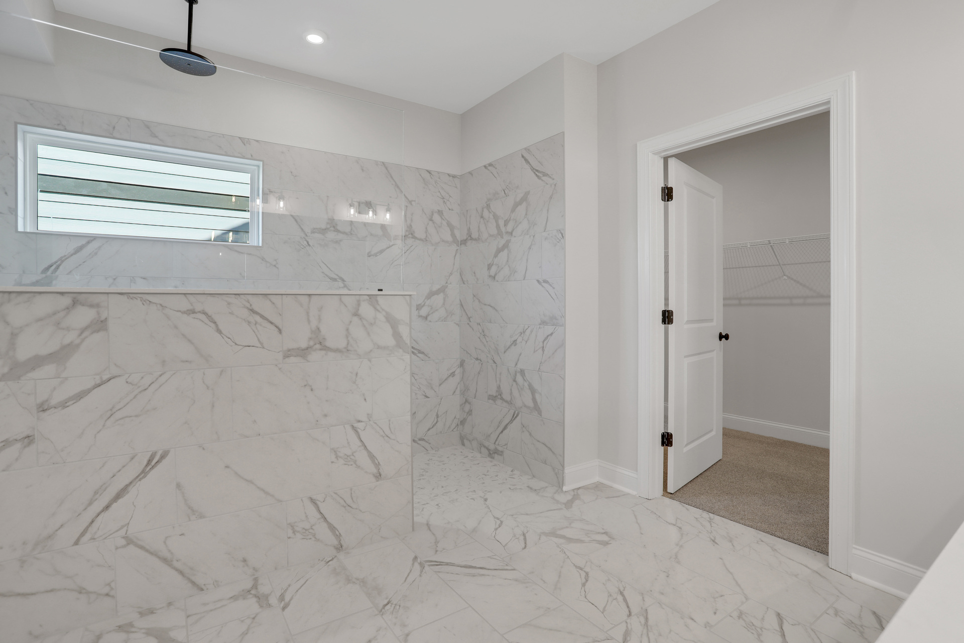 primary bathroom with large walk-in shower and tile floors