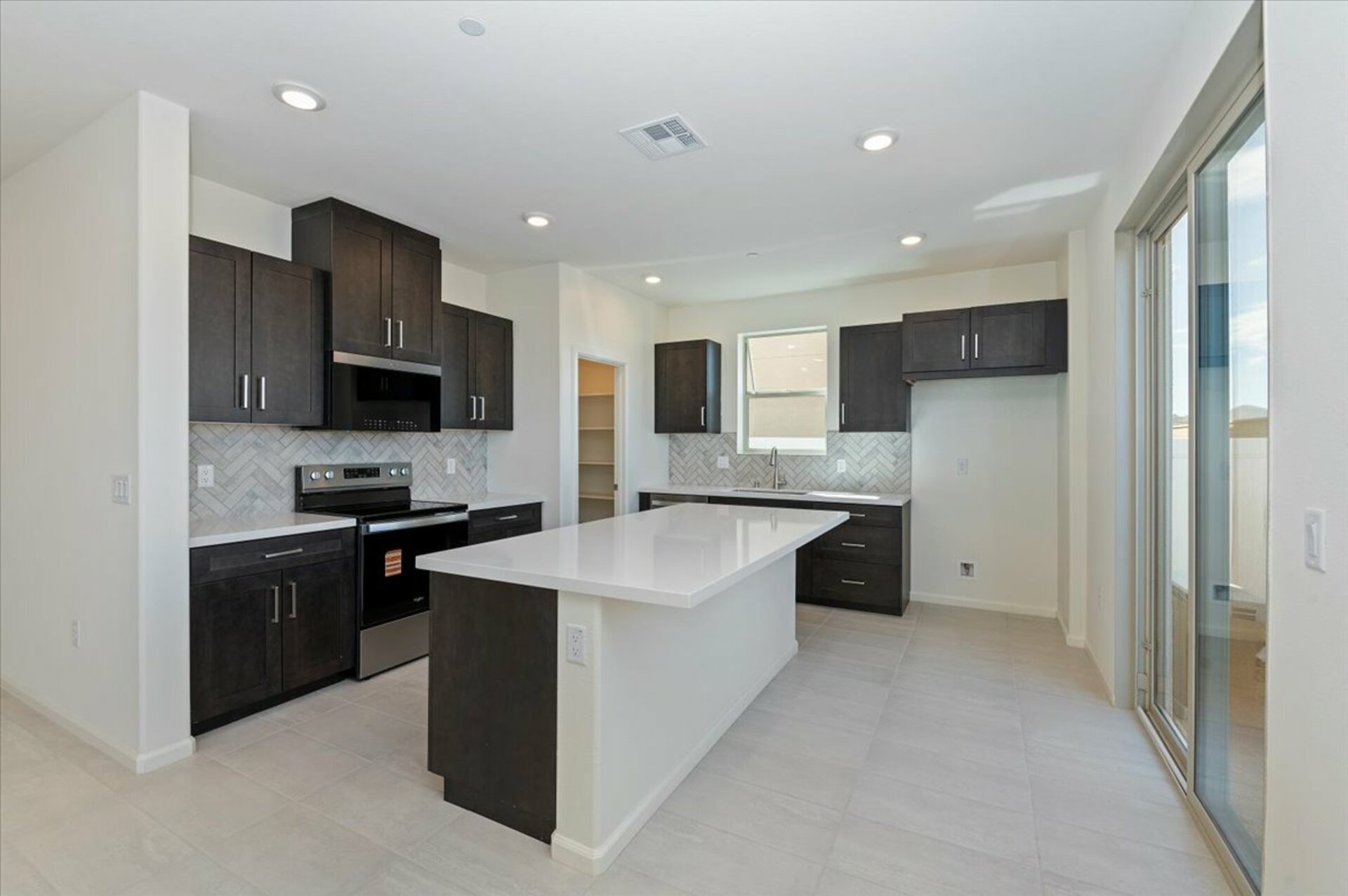 kitchen featuring a large white island and dark brown cabinets