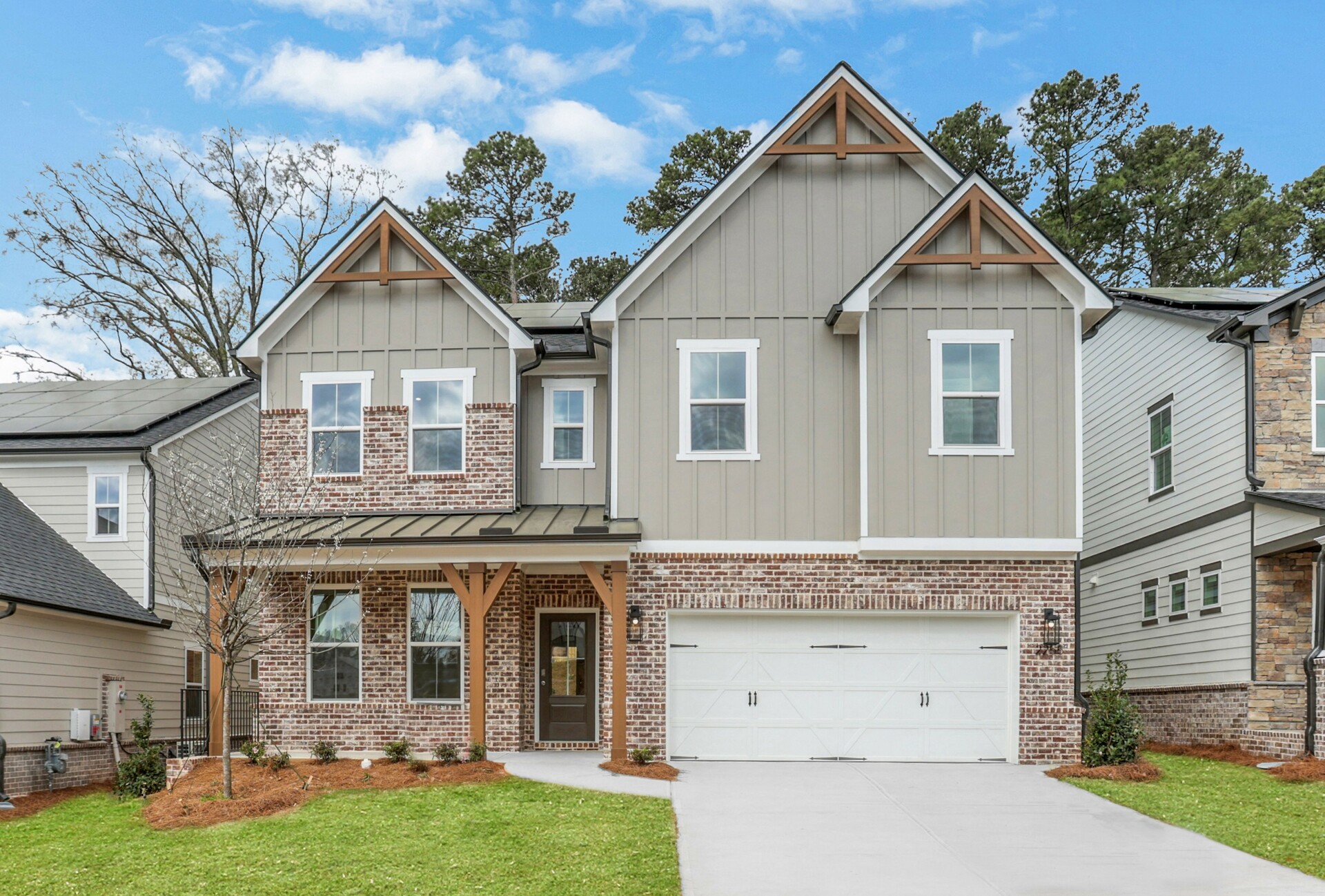 front of 2-story home with light siding and 2-car garage