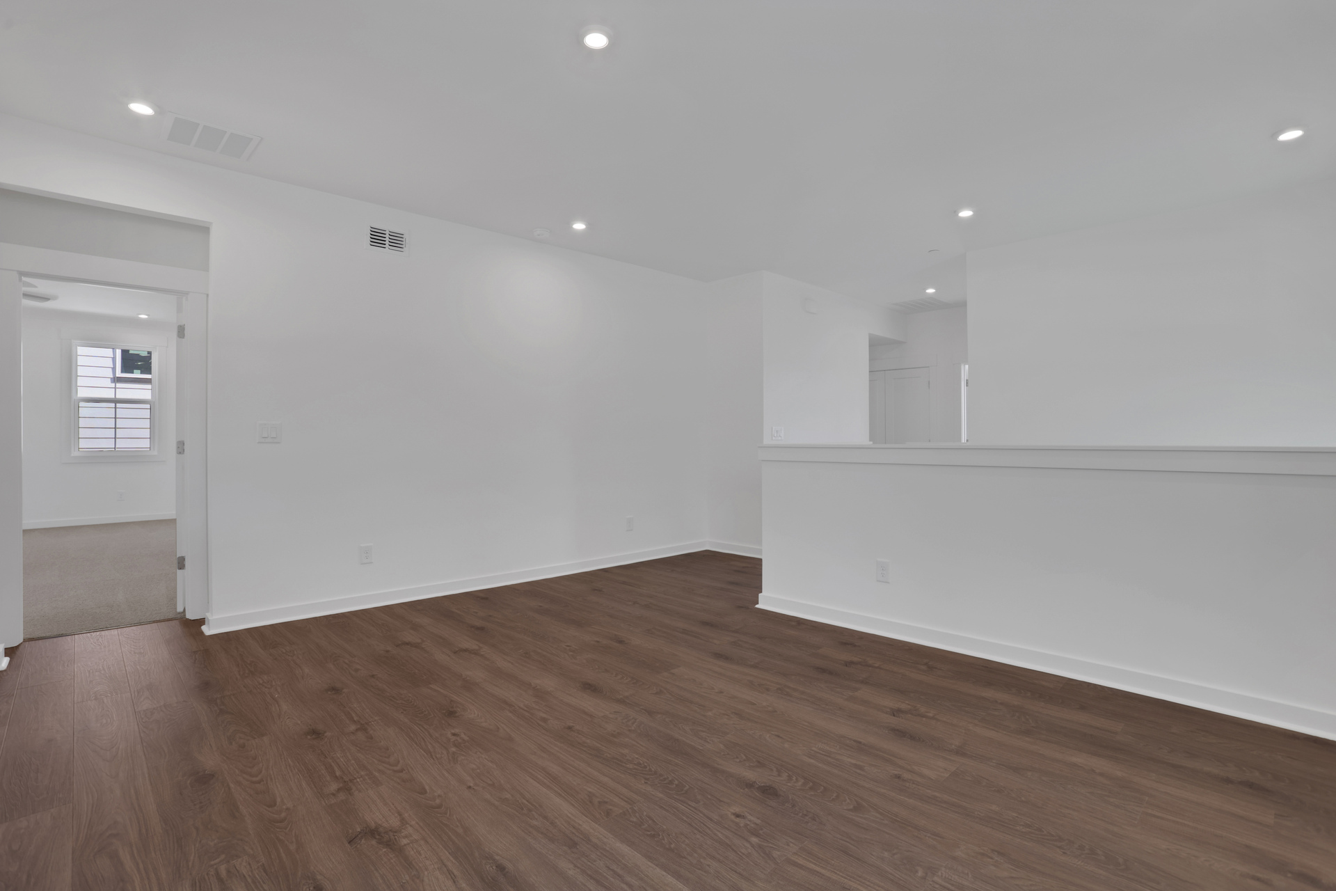 loft with hard surface floors and white walls