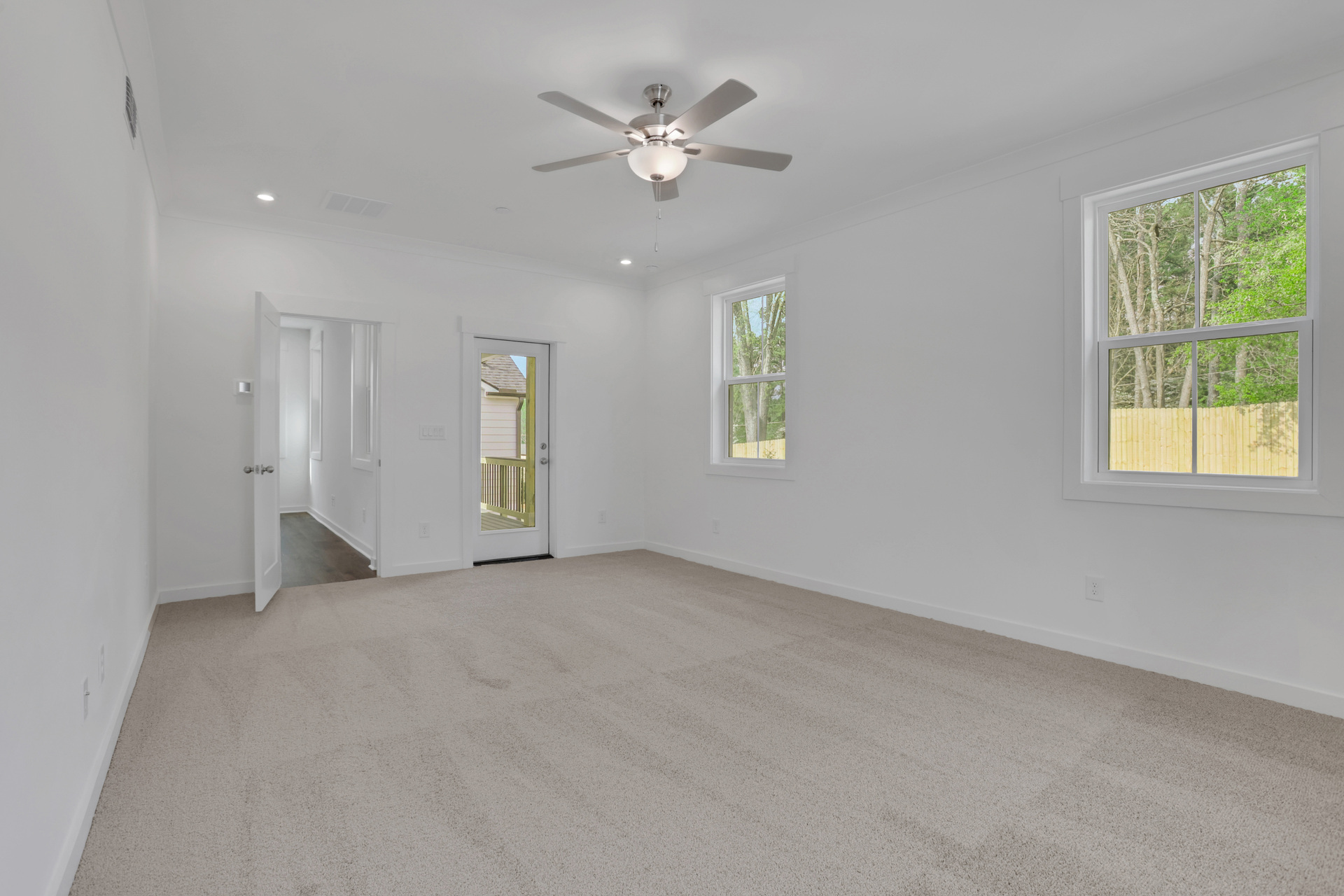 primary bedroom with private balcony and carpet