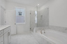 bathroom with white tile floor and bathtub