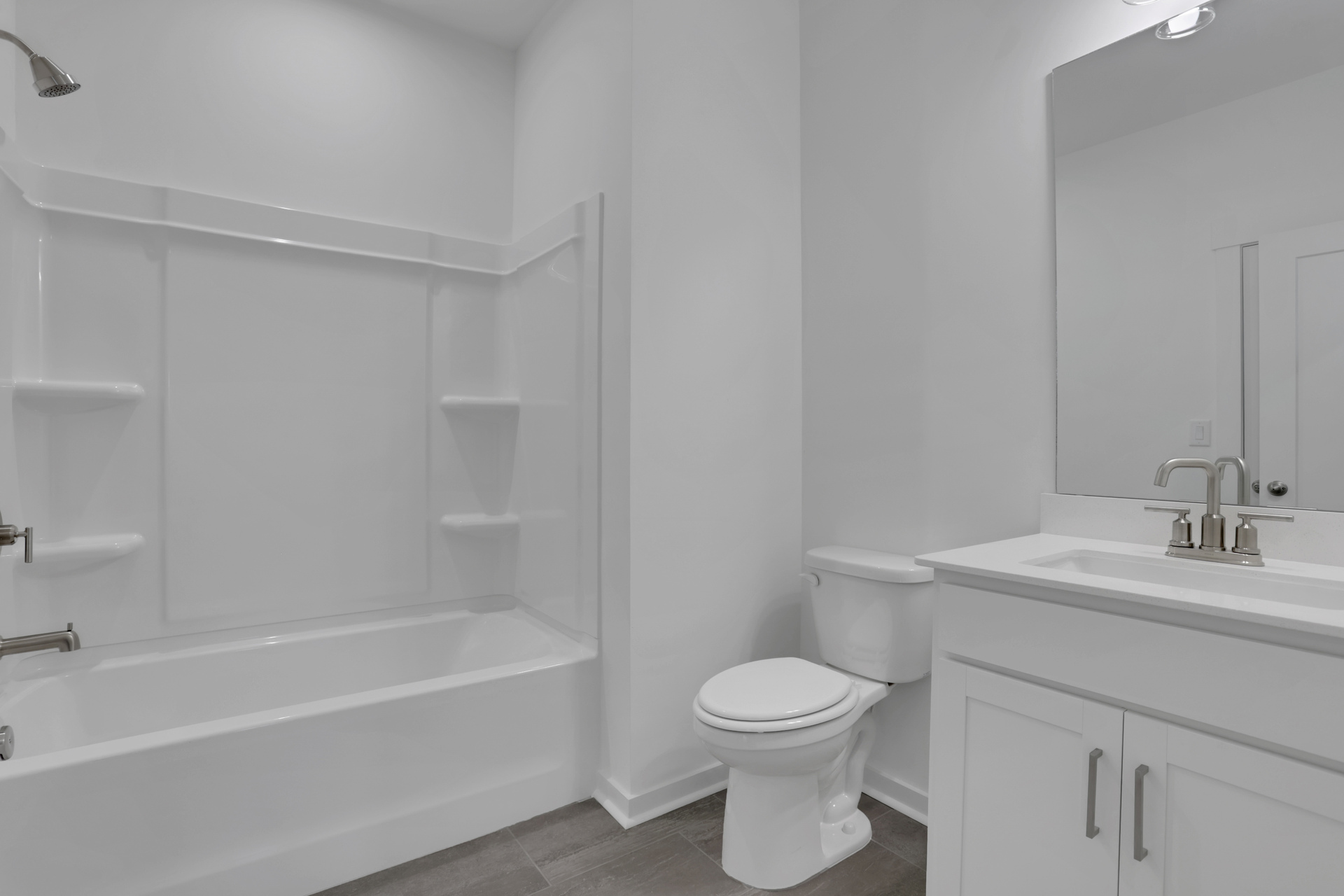 bathroom with white tile floors and bath tub