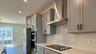 gray cabinets and white tile with electric stove