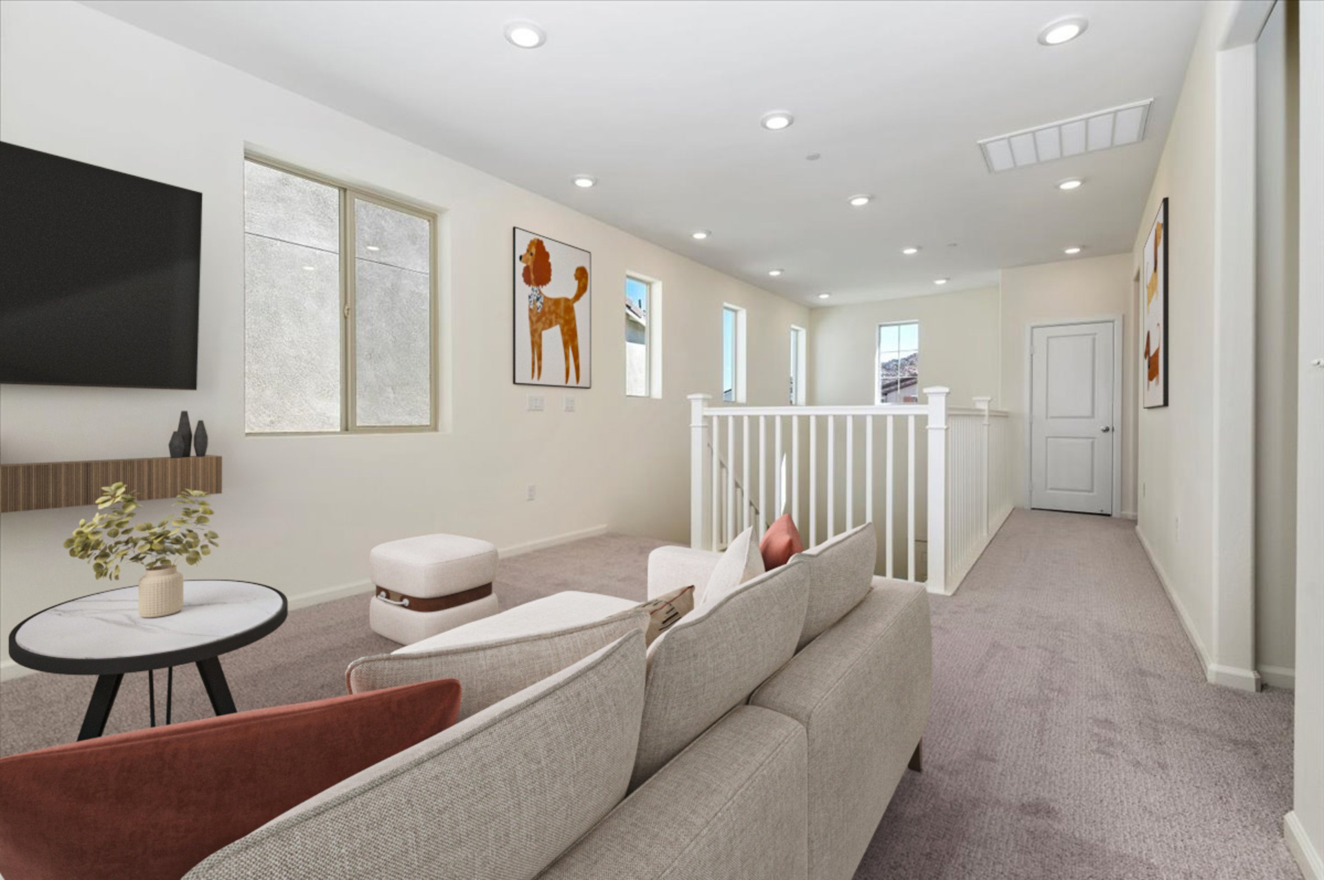 loft with a white couch, a small circular coffee table, and a mounted flatscreen