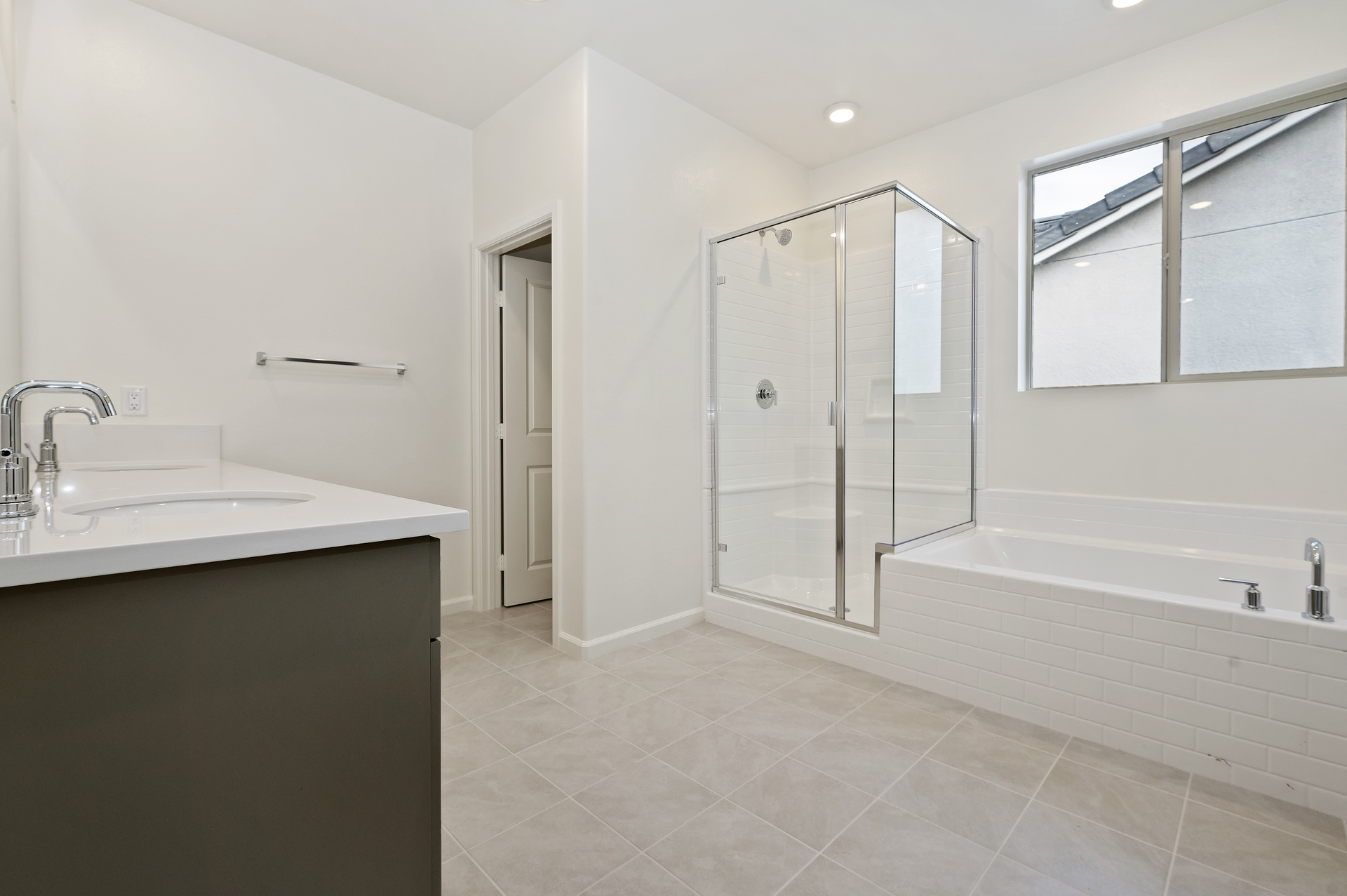 primary bathroom with neutral floors and white countertops