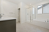 primary bathroom with neutral floors and white countertops