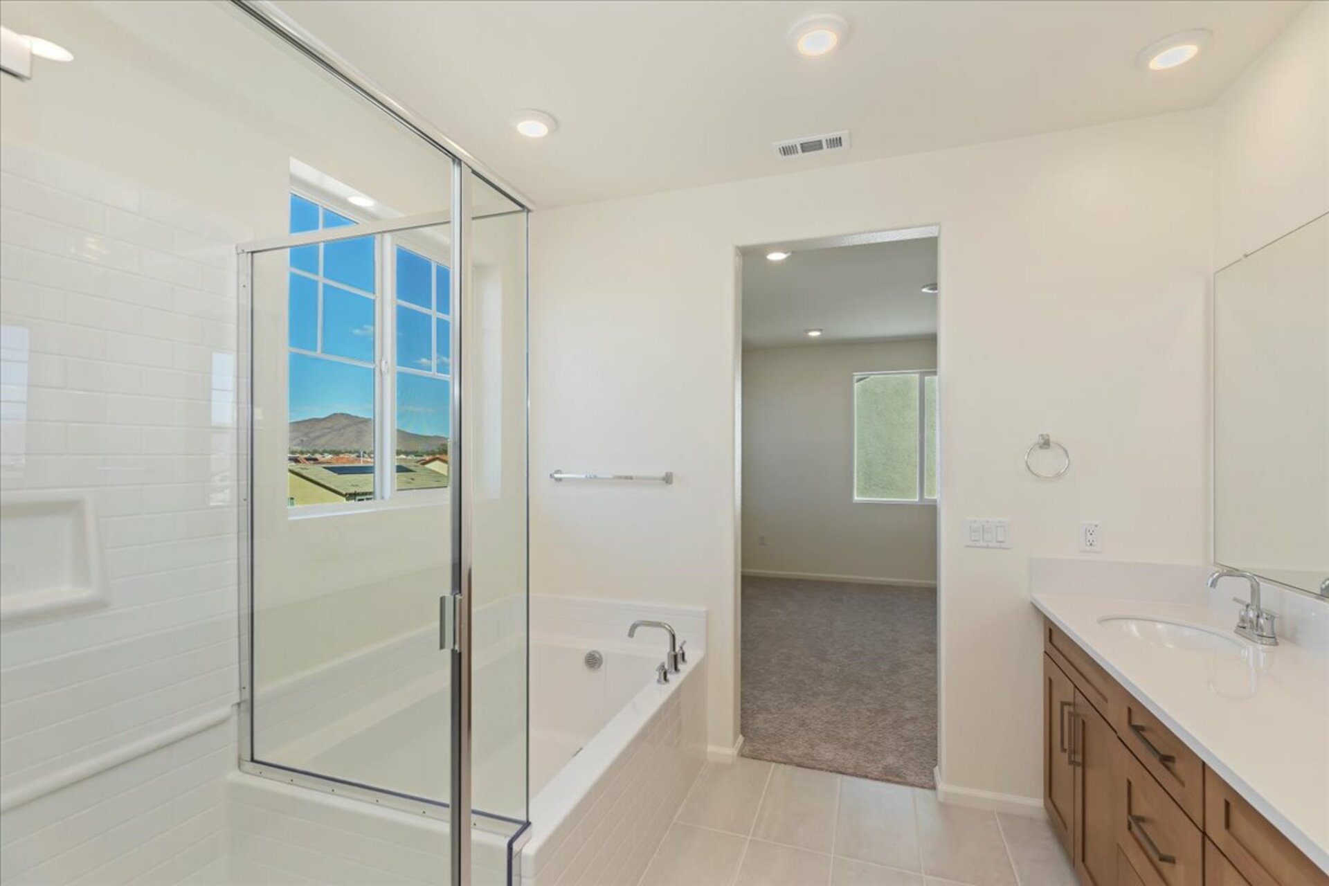 bathroom with a large glass walk-in shower and a soaking tub