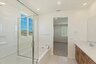 bathroom with a large glass walk-in shower and a soaking tub