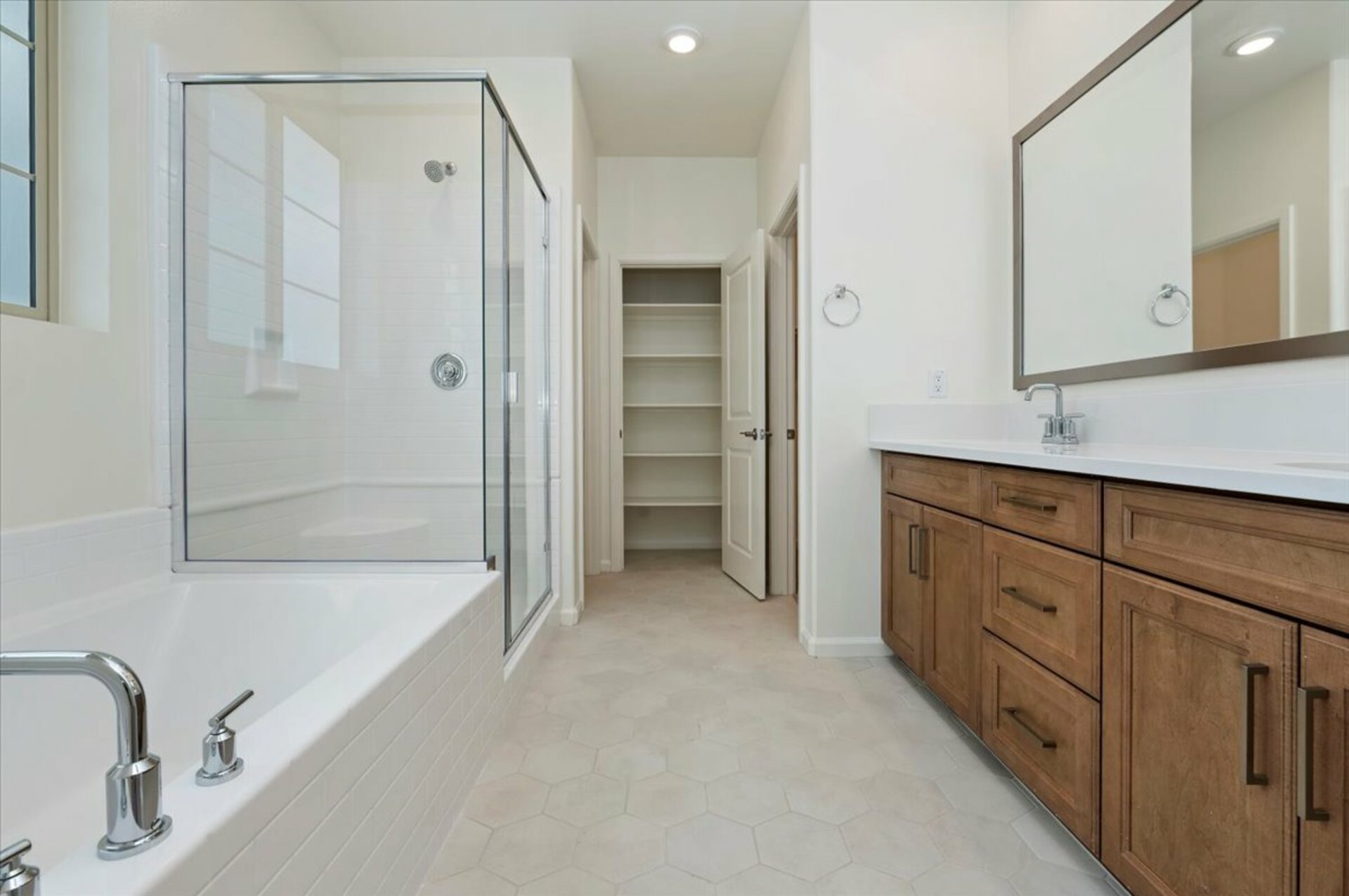 primary bathroom with neutral floors and dual sinks
