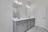 primary bathroom with gray cabinets and tile flooring