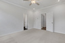 primary bedroom with windows and carpet