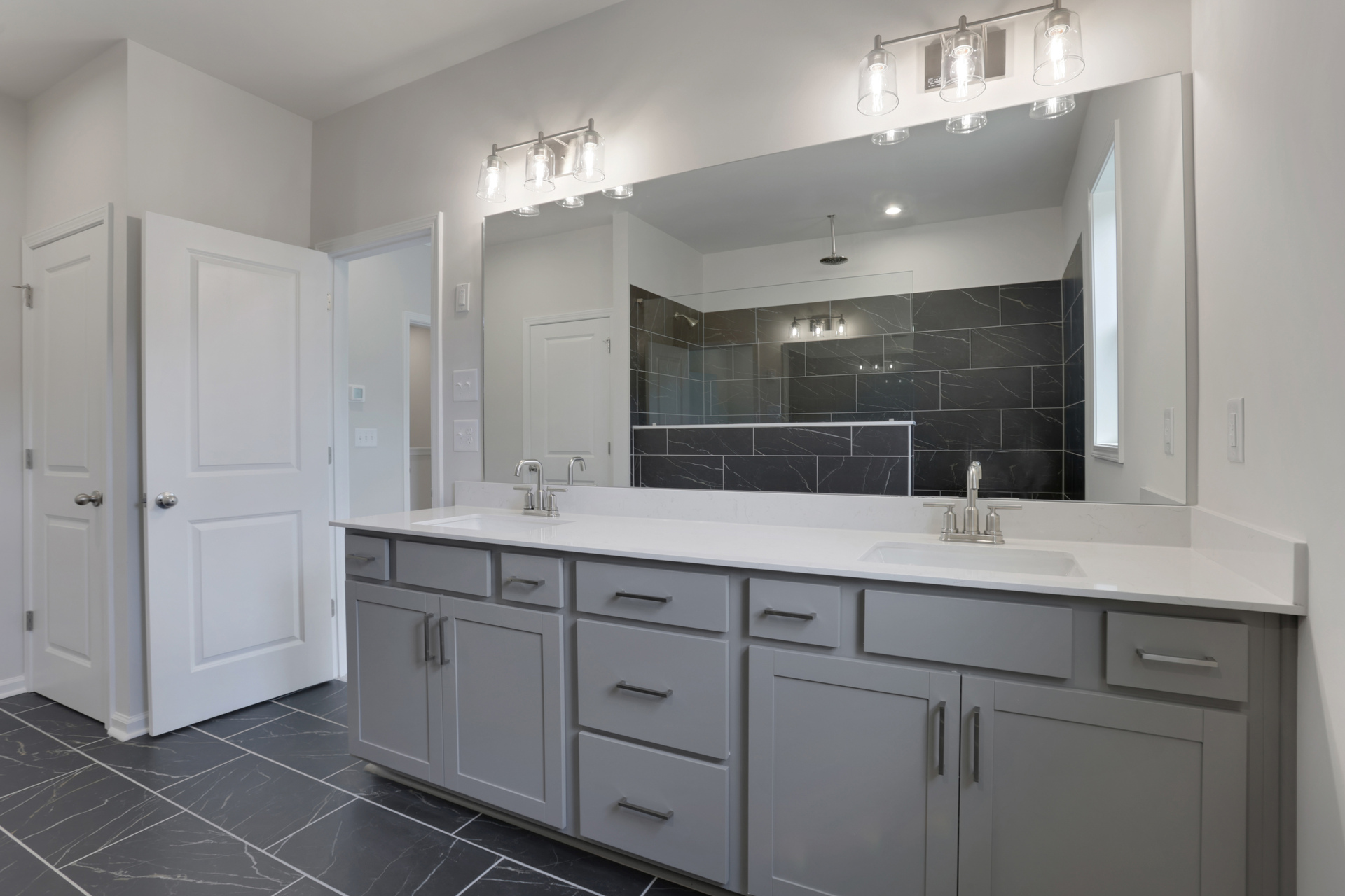 primary bathroom with gray cabinets and tile flooring