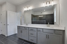 primary bathroom with gray cabinets and tile flooring