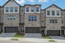 front of 3-story townhome with dark brick and light siding