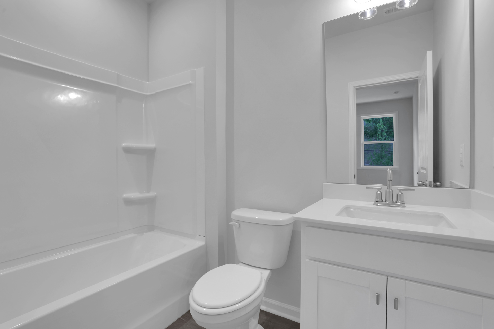 secondary bathroom with white cabinets and tile flooring