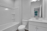 secondary bathroom with white cabinets and tile flooring
