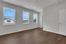 primary bedroom with windows and hard surface flooring 