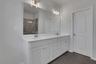 primary bathroom with white cabinets and tile flooring