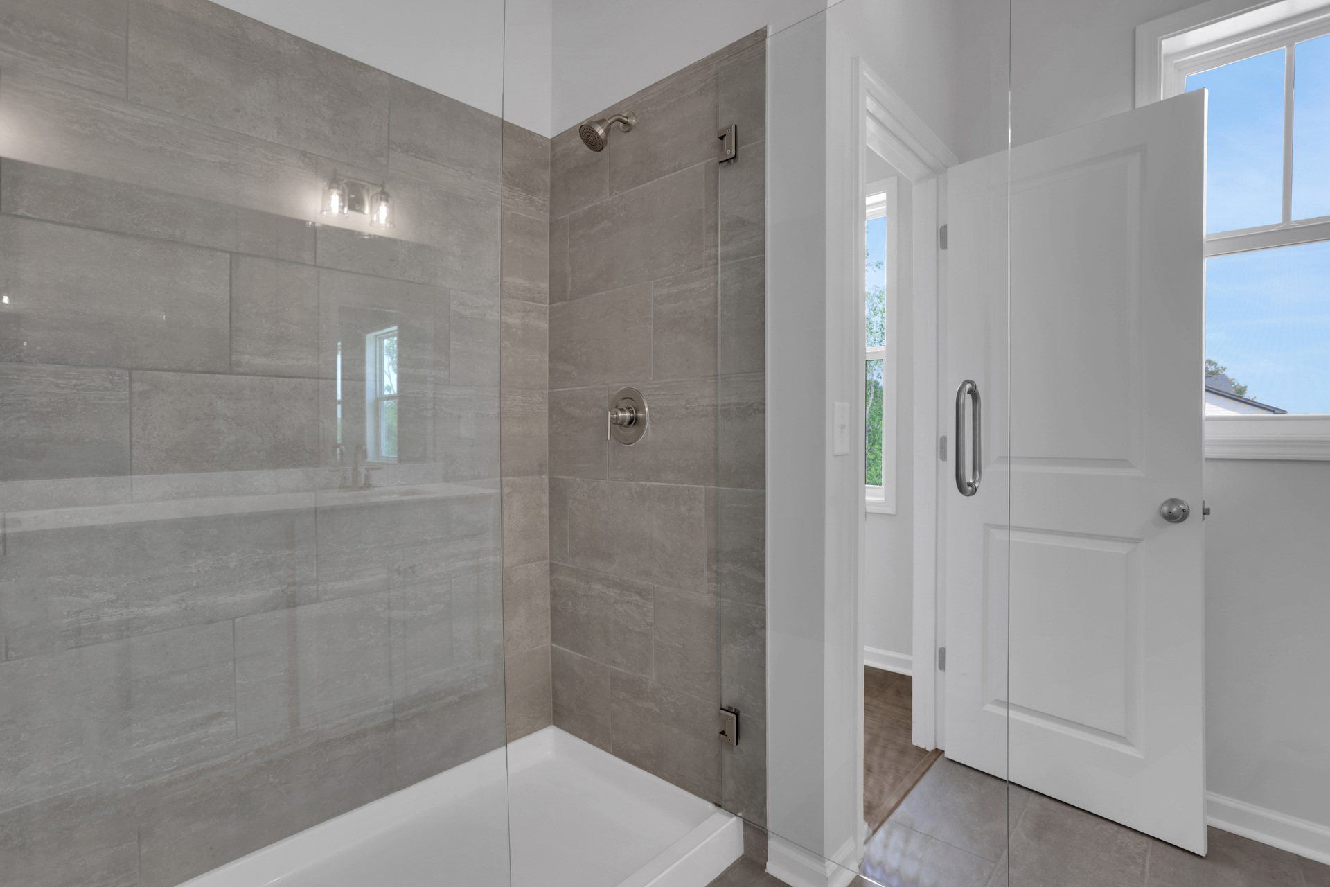 primary bathroom with walk-in shower and tile flooring