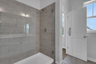primary bathroom with walk-in shower and tile flooring