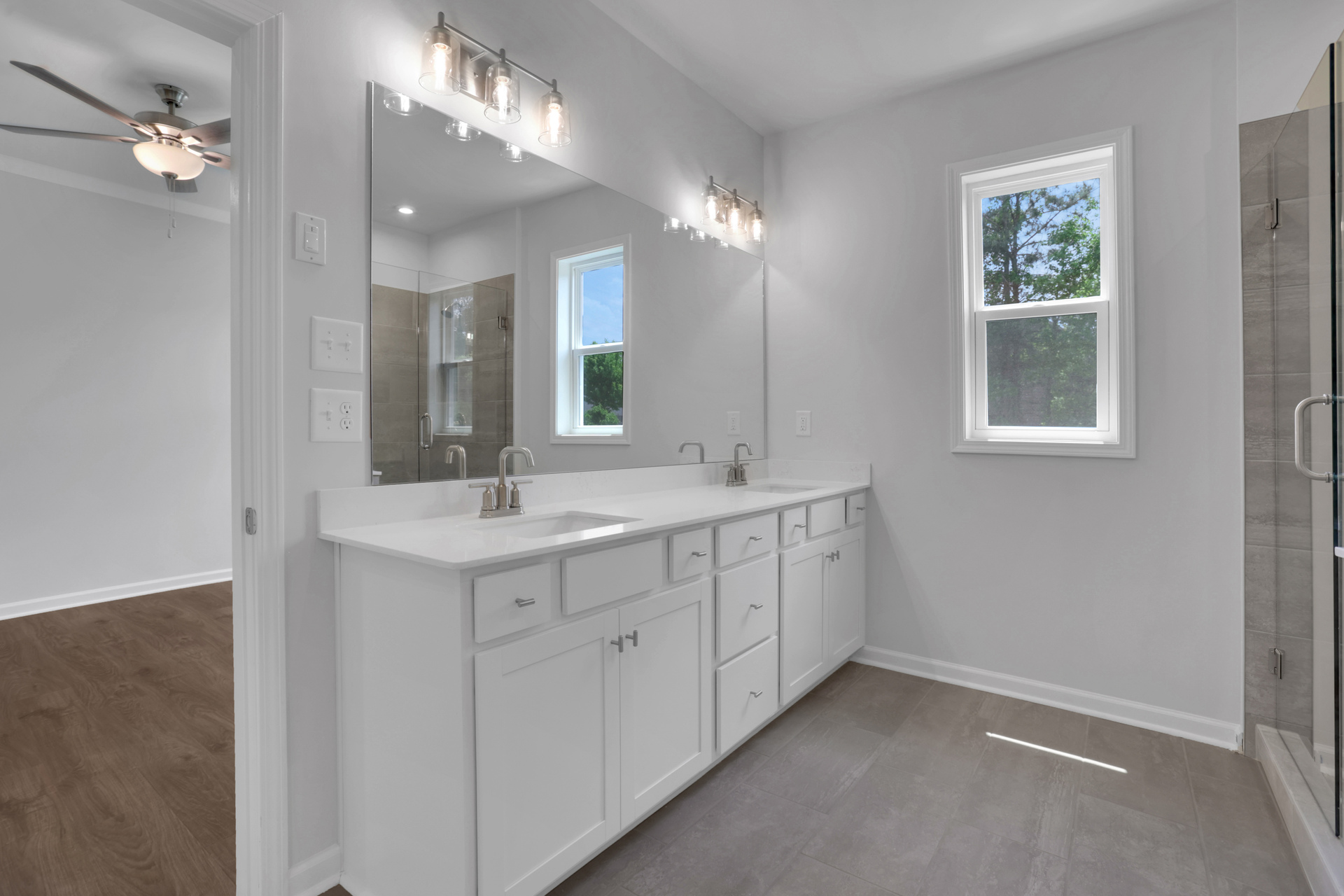 primary bathroom with white cabinets and tile flooring