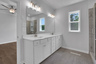 primary bathroom with white cabinets and tile flooring