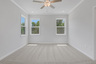 primary bedroom with windows and carpet