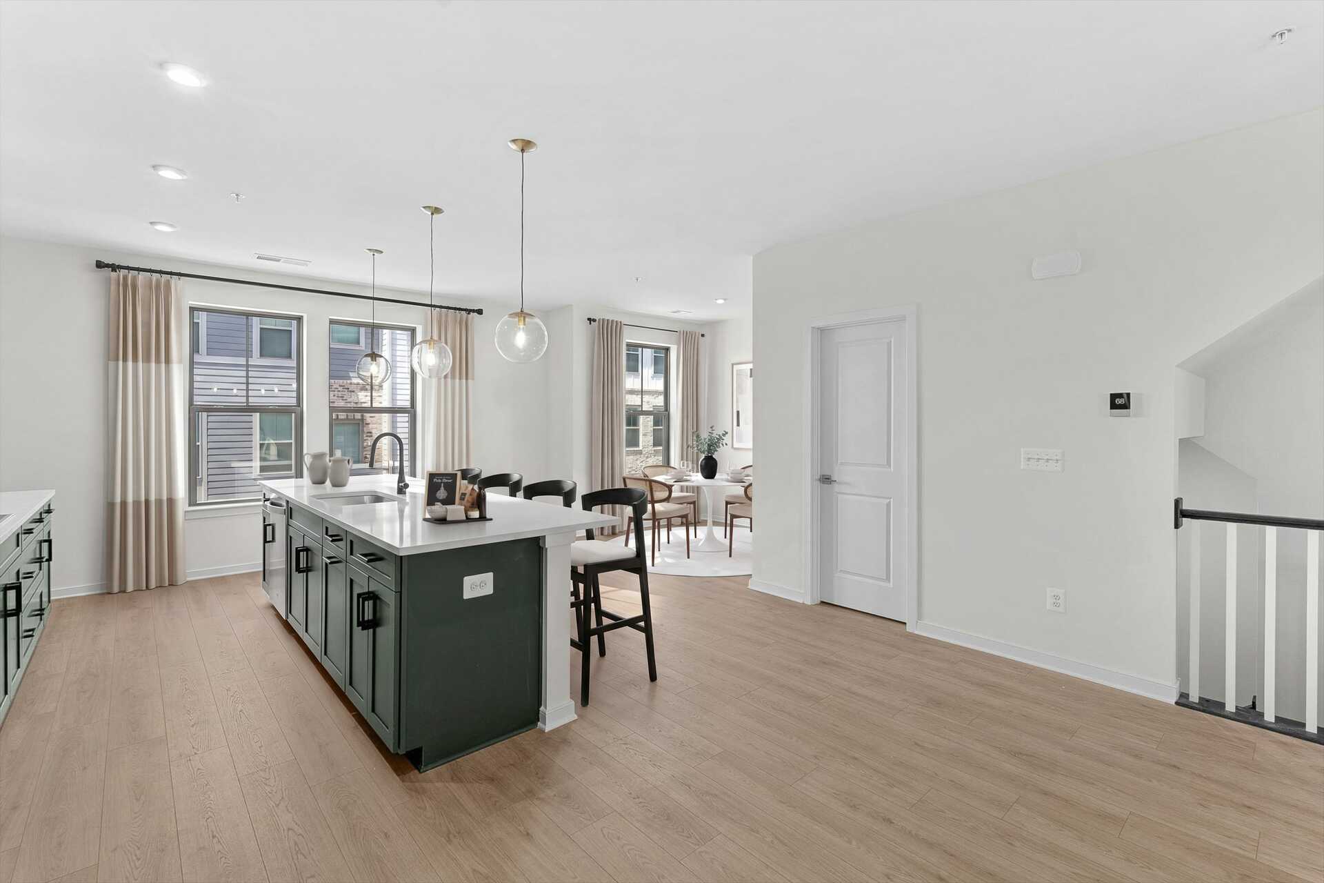 kitchen island with green cabinets and pendant lighting