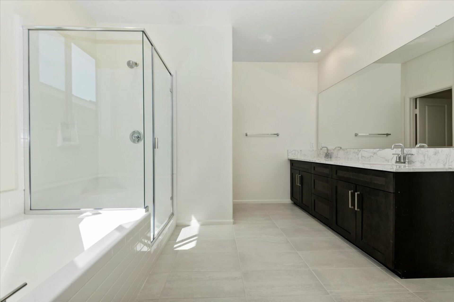 primary bathroom with a dual vanity sink and large walk-in shower and soaking tub