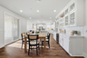 dining room with built-in white cabinets, beverage refrigerator, wood floors, sliding glass door, and wood table with six black chairs