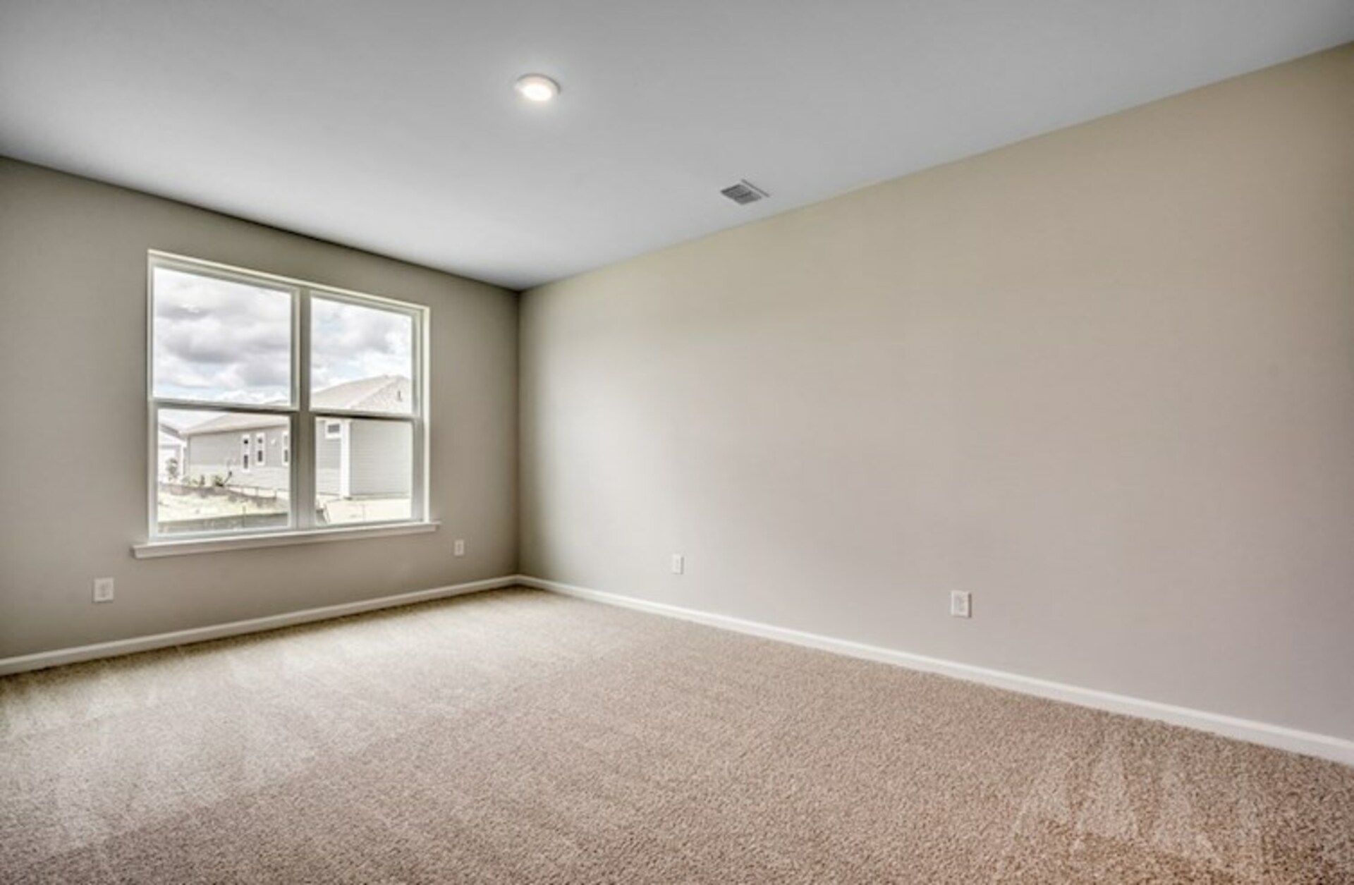 spacious room with large windows for natural light and carpeting throughout