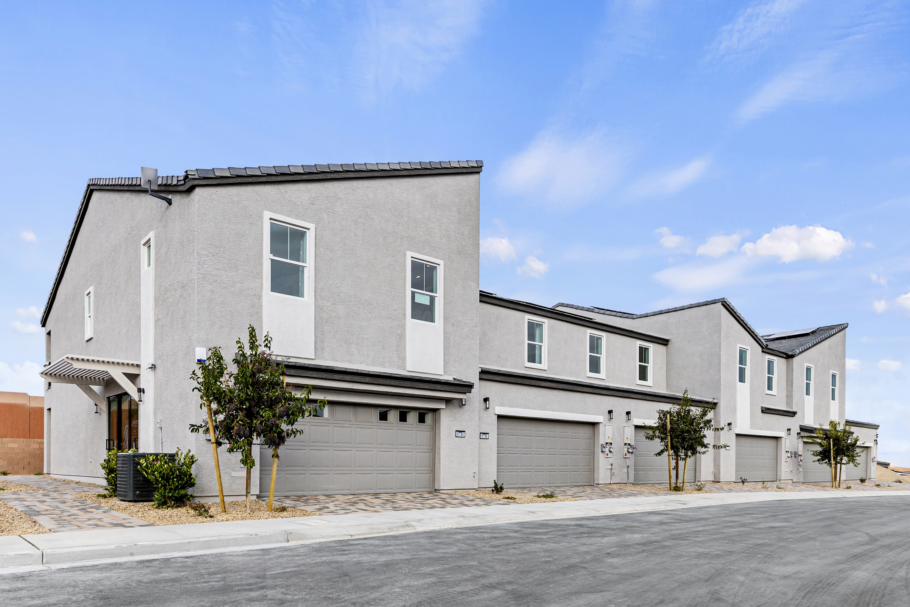 grey townhome buildings with stone driveways