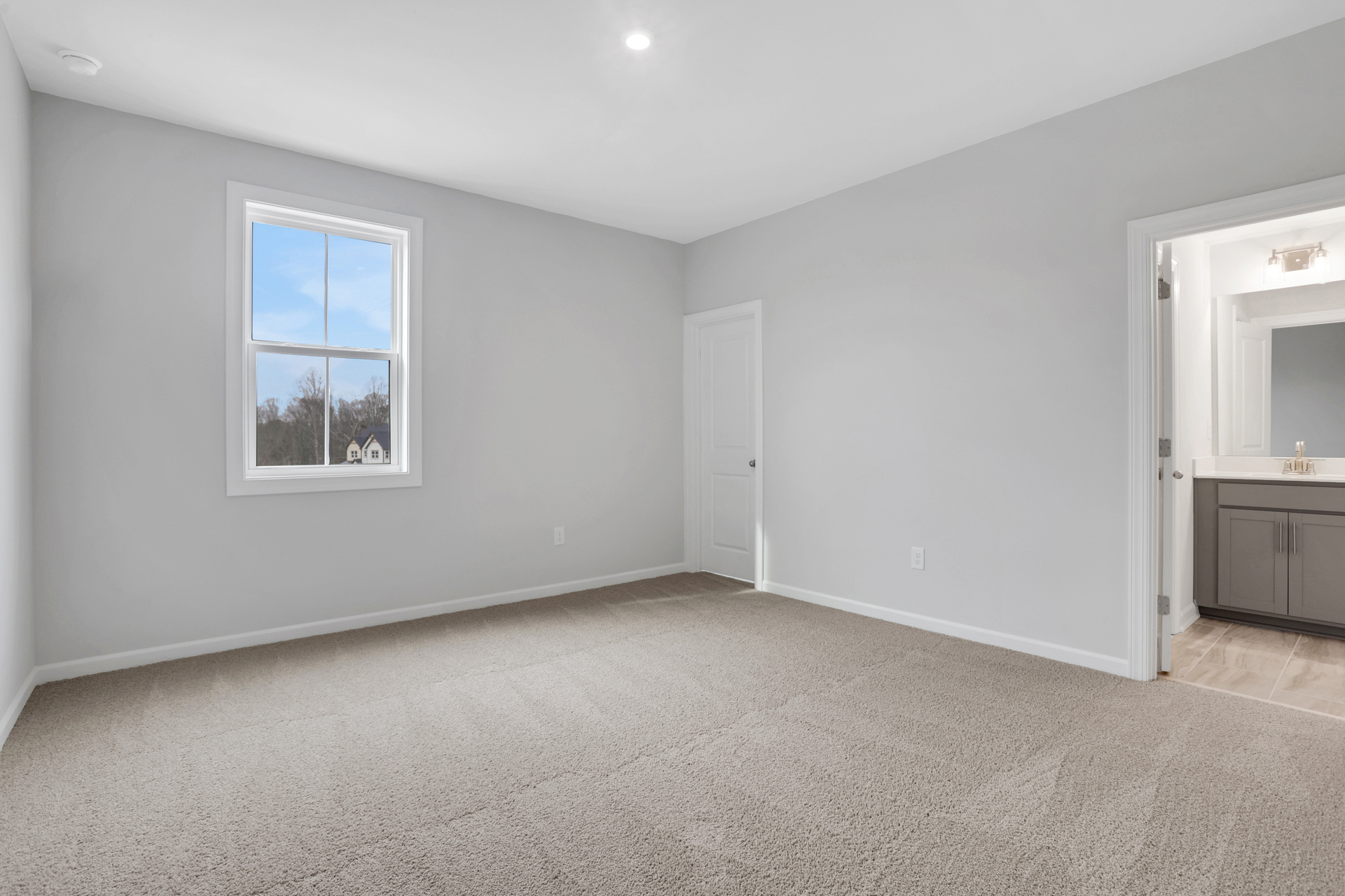 bedroom with ensuite bath and carpet