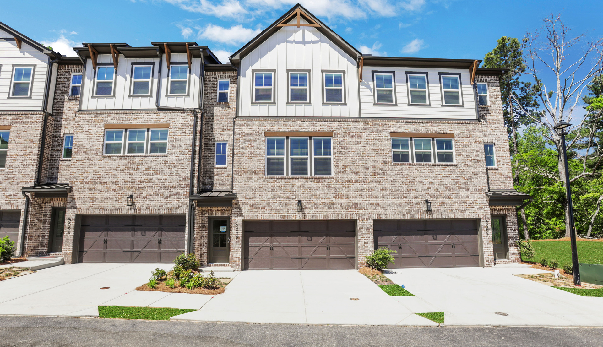 front of 3-story townhome with brick and light siding