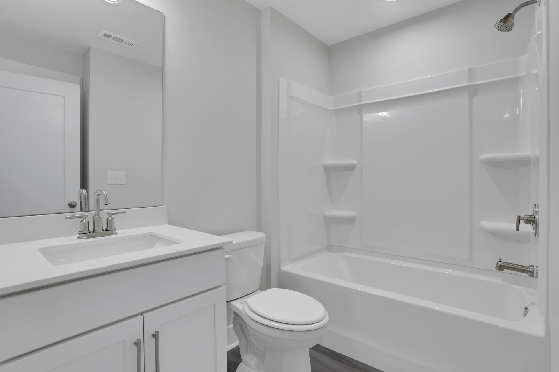 secondary bathroom with white cabinets and quartz counters