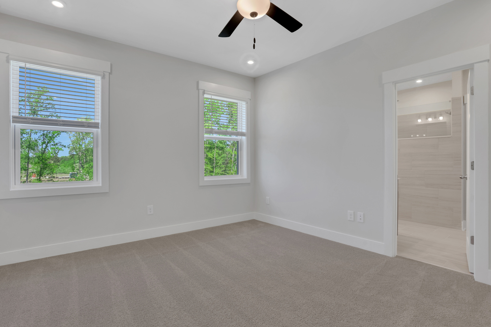 primary bedroom with carpet and windows