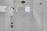 primary bathroom with walk-in shower and tile flooring