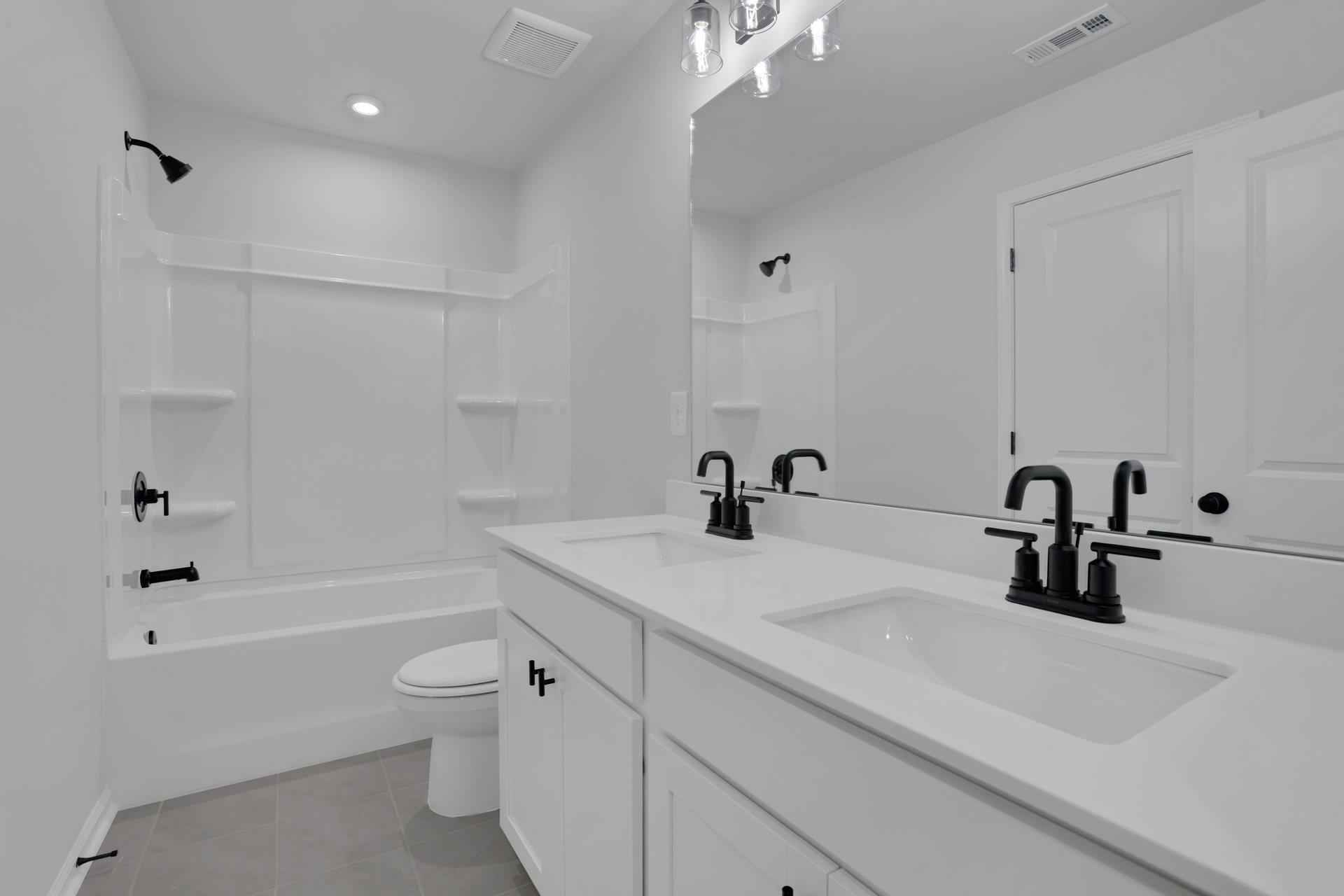 secondary bath with dual vanity and white cabinets