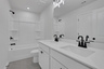 secondary bath with dual vanity and white cabinets